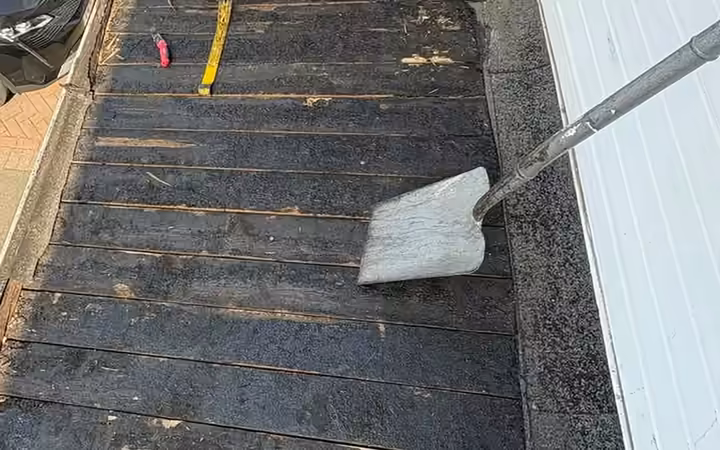 Old flat roof stripped back showing a rotten timber deck before replacement